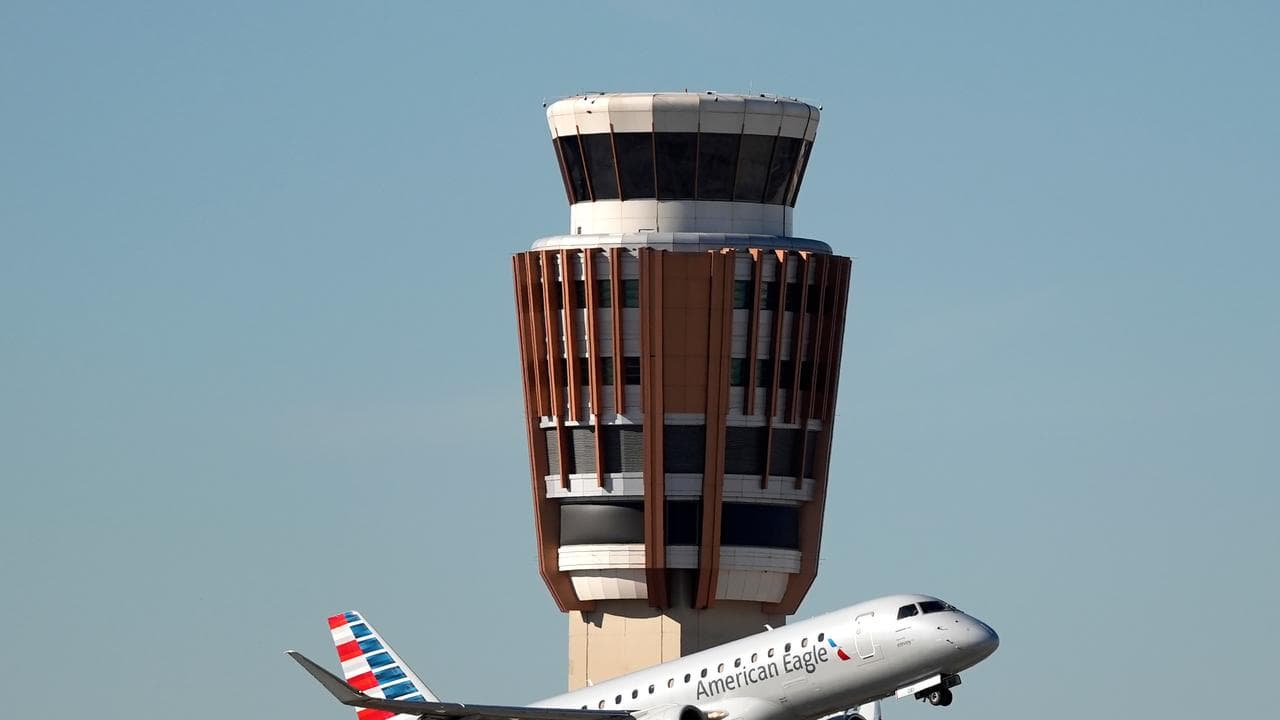 A jet flies past the air traffic control tower