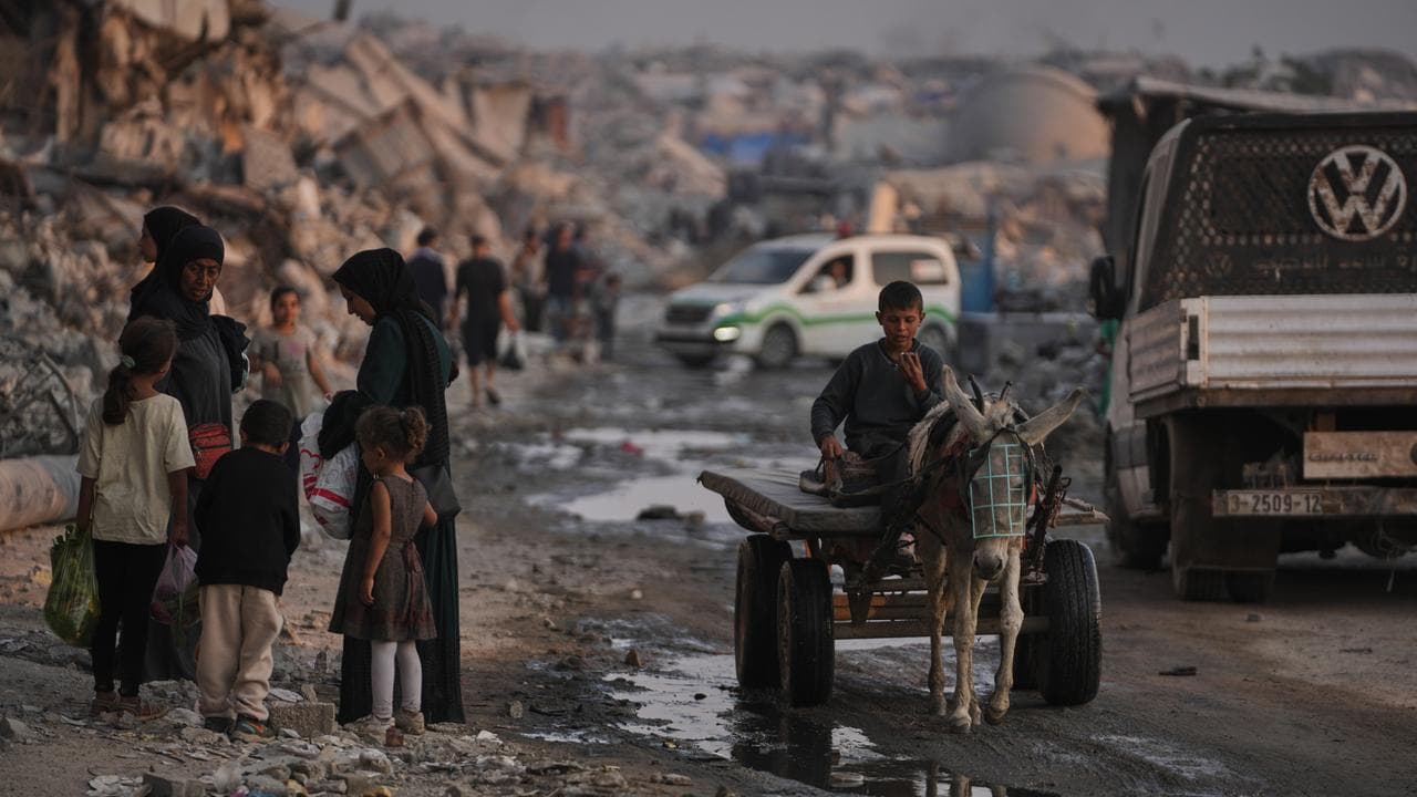 Palestinians walk through destruction