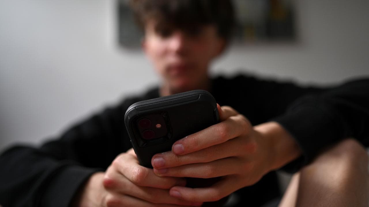 A teenager uses his mobile phone to access social media, Sydney