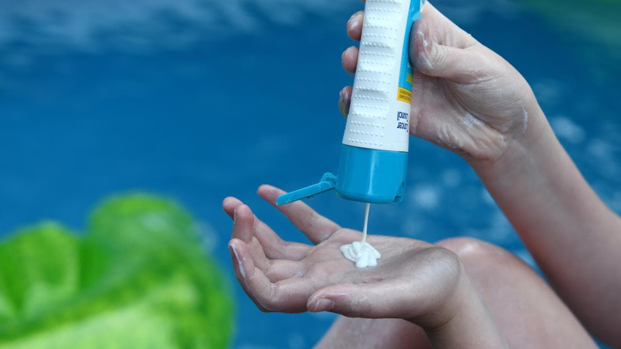 A child applies sunscreen i