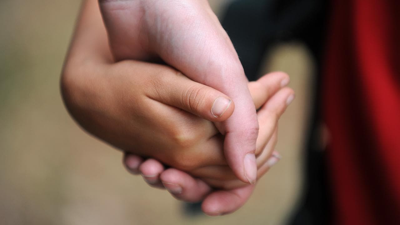 Someone holding a child's hand