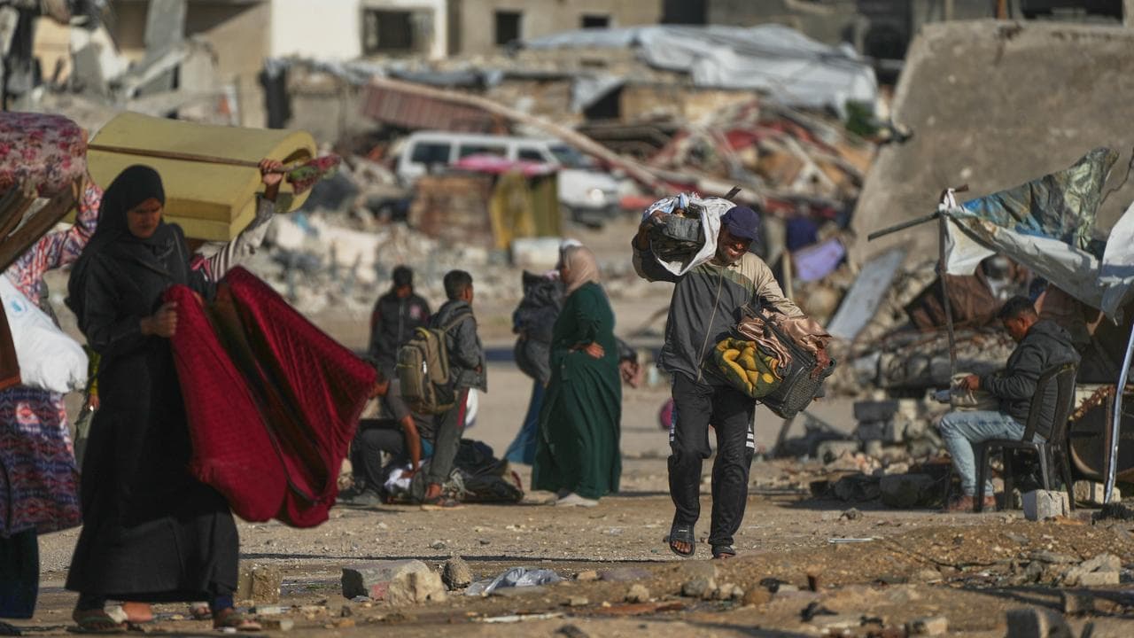 A Palestinian man carries bags of firewood in Khan Younis, Gaza Strip