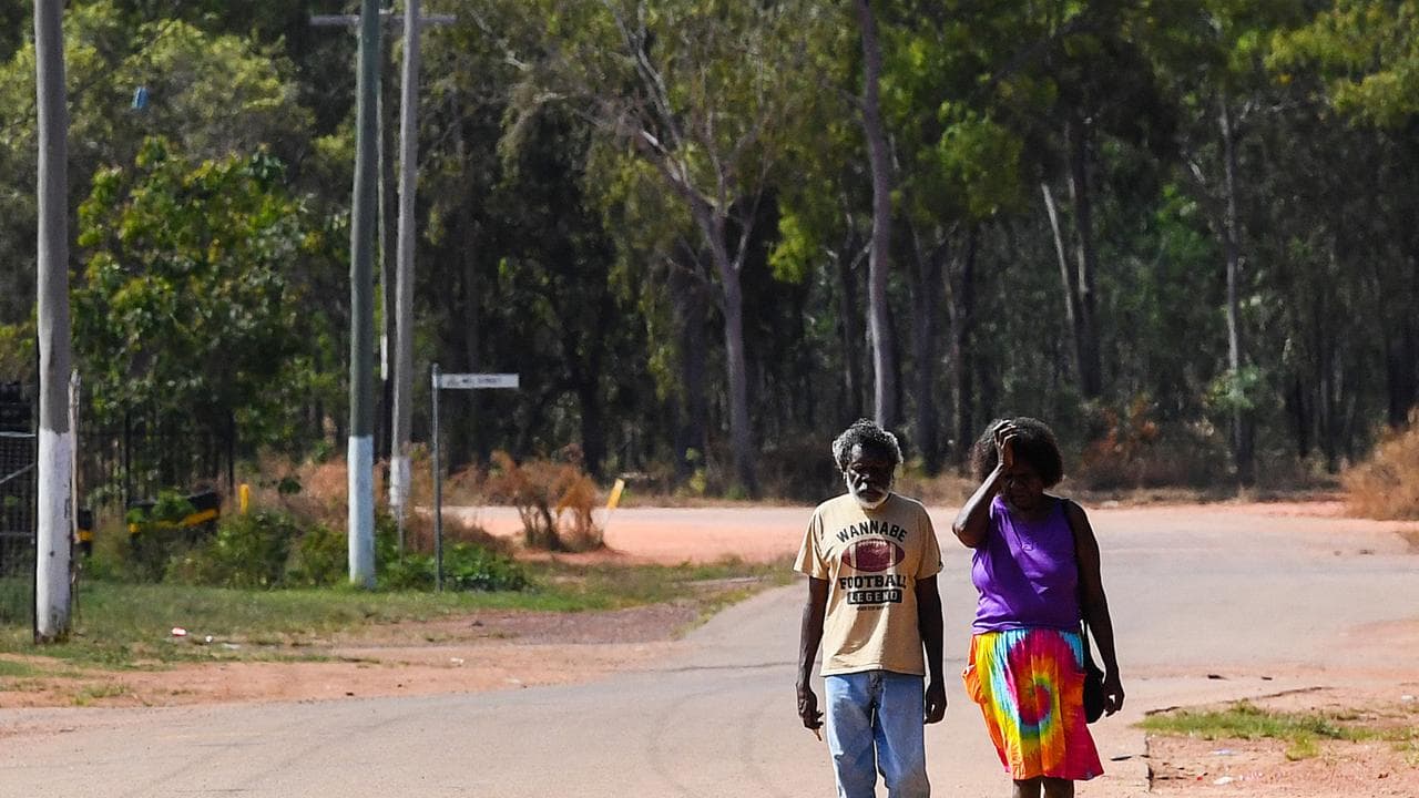 A photo of two Indigenous people walking down the street.