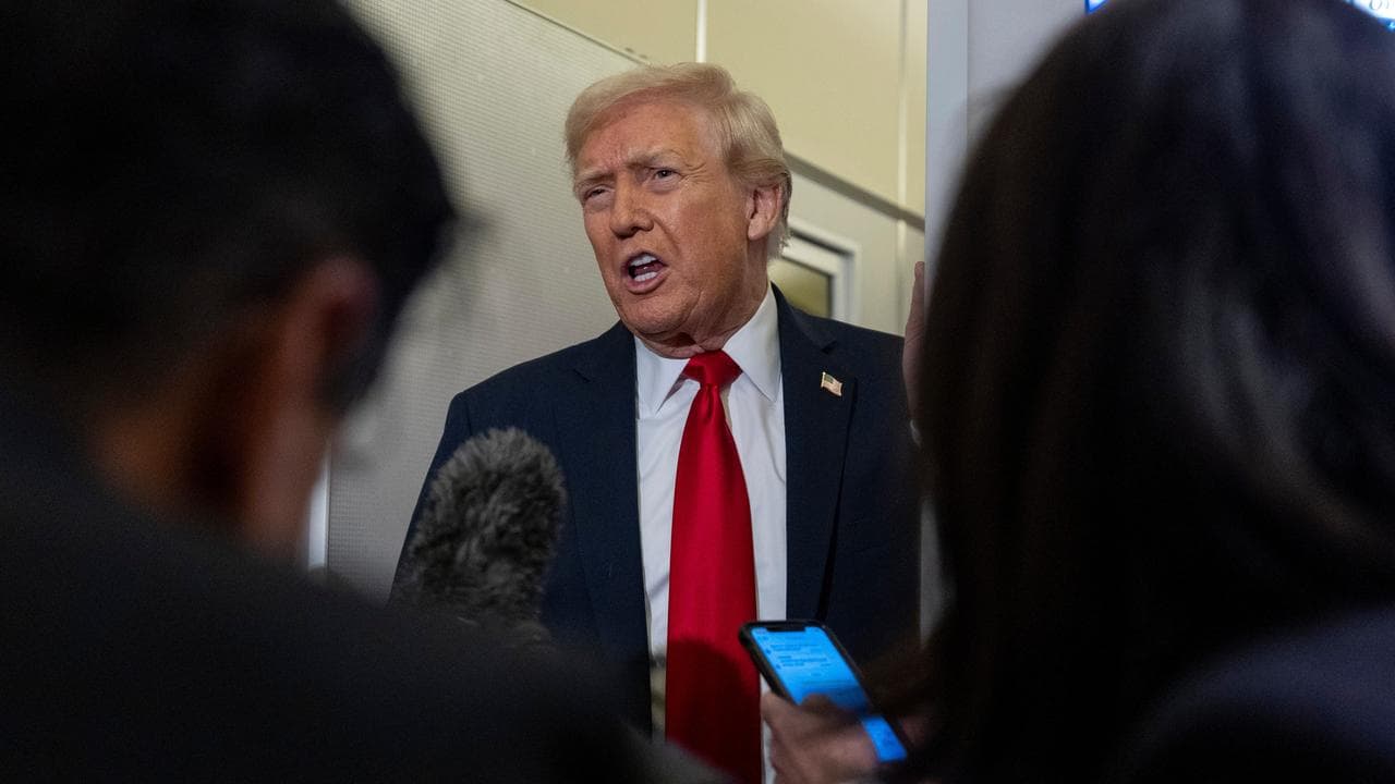 US President Donald Trump speaks to reporters on Air Force One