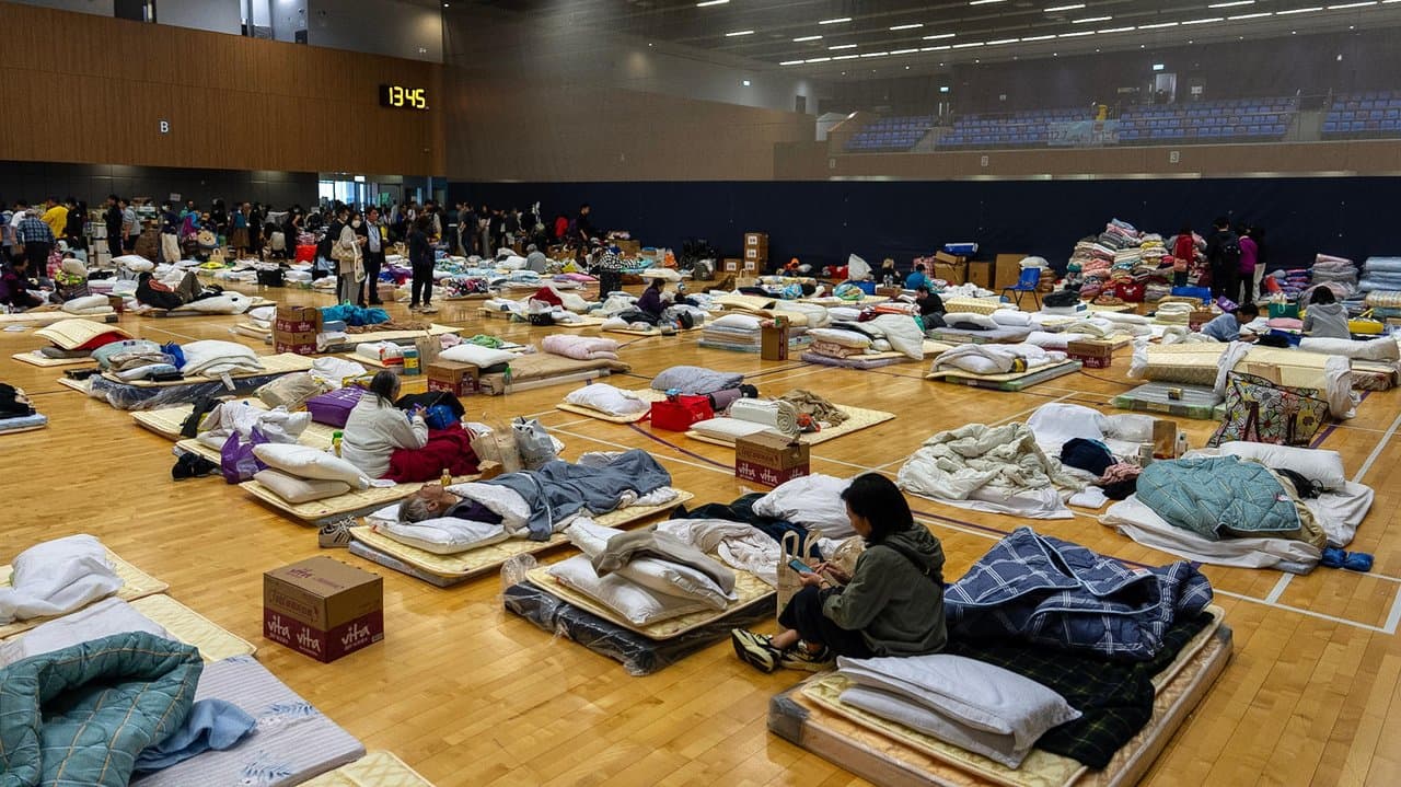 Residents rest at a shelter near the fire scene at Wang Fuk Court