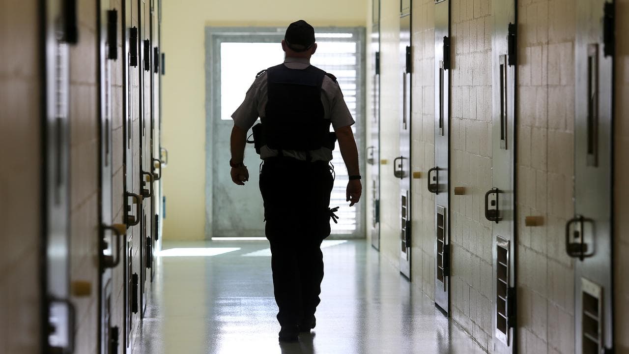 A corrections officer walks down a cell corridor (file image)