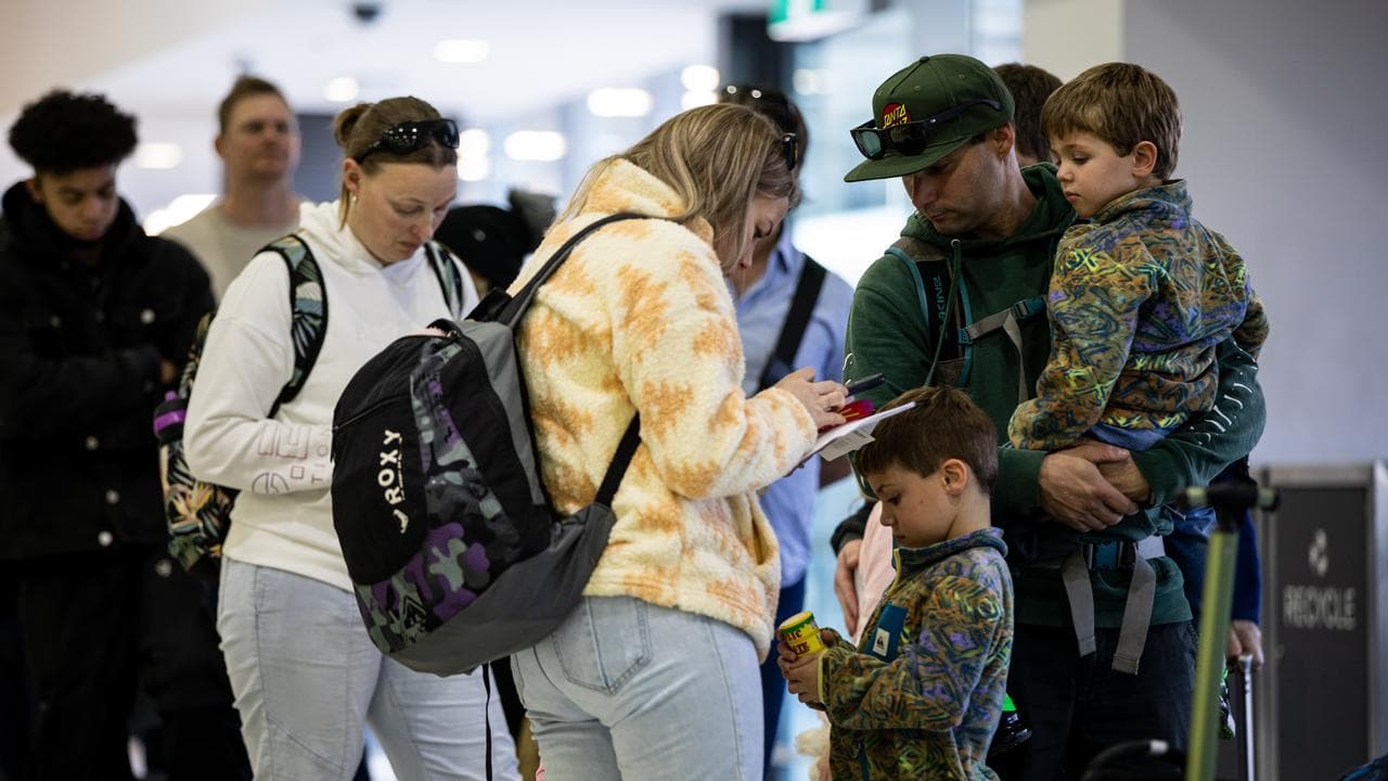 Travellers use their phone while queuing at check-in counters 