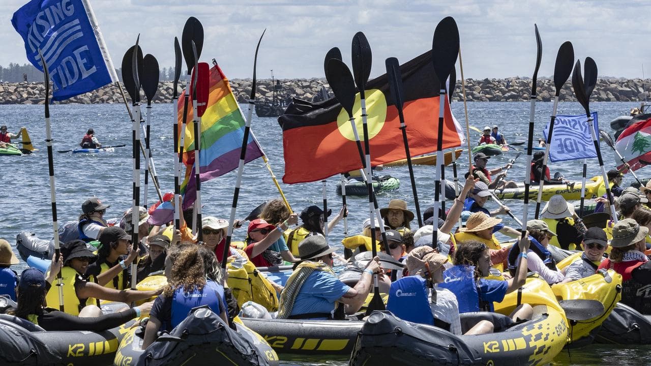 Protesters paddle into the ocean during a coal export protest