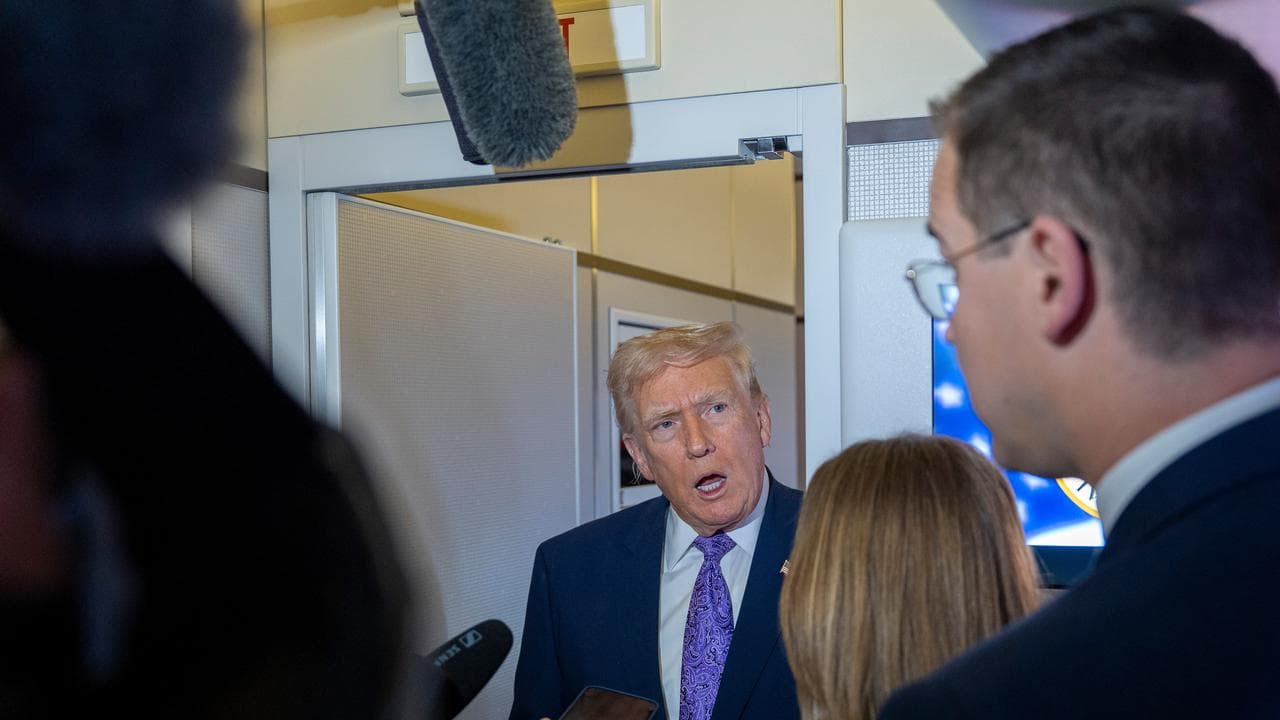 Donald Trump speaks with reporters while in flight on Air Force One