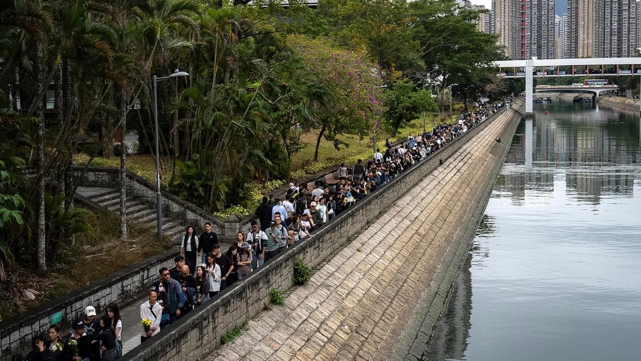 People line up to pay respects for victims of the Wang Fuk Court fire