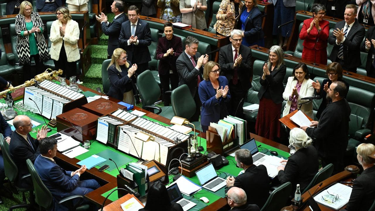 Members of the Victorian parliament stand to applaud a speech