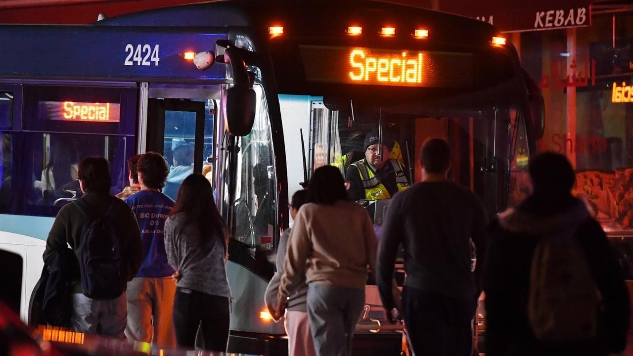 People board a bus in a neighbourhood near Brown University