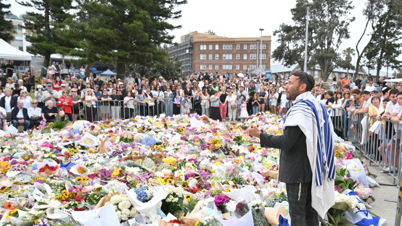 A rabbi addressing mourners at a makeshift memorial at Bondi Beach