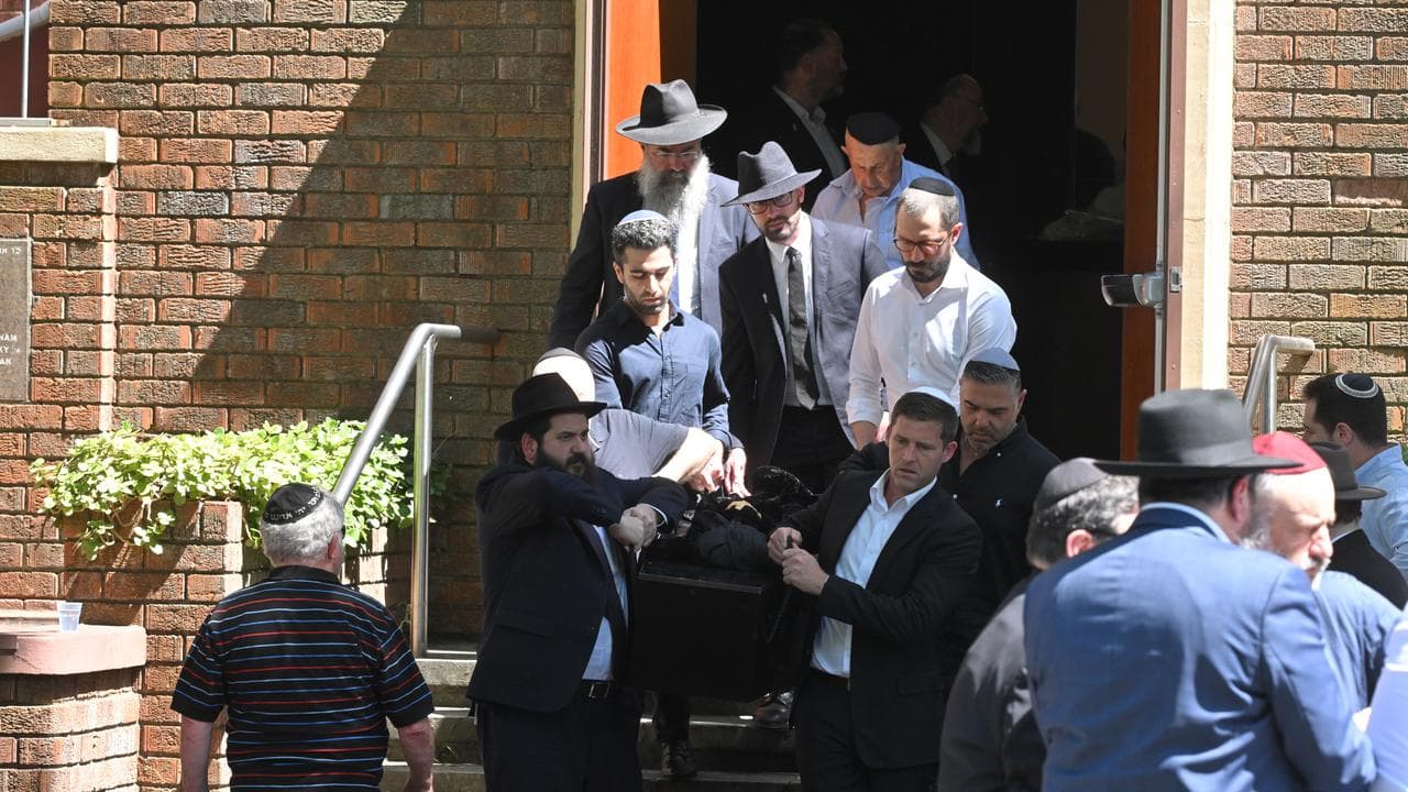 Mourners carry out the caskets