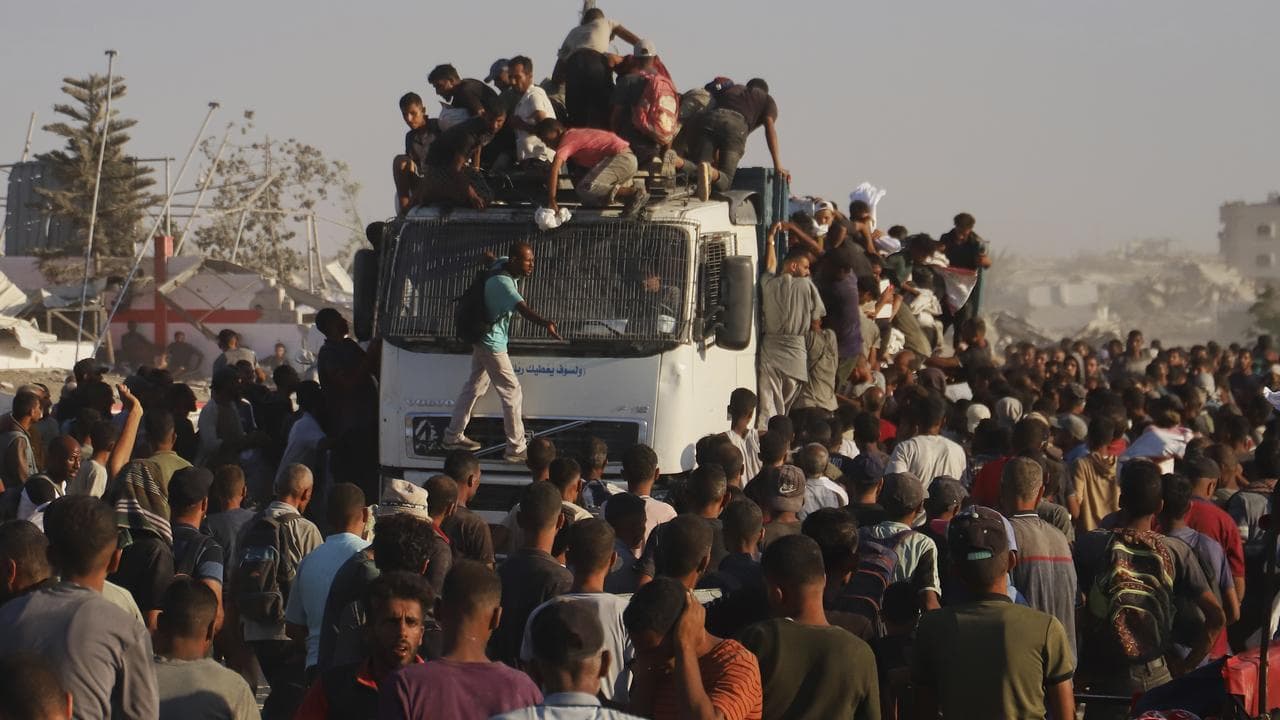 Palestinians ride on an aid truck in the southern Gaza Strip