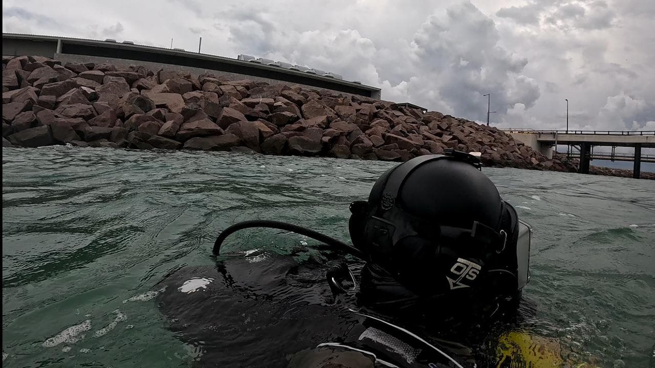 Divers search for the body of a man seen floating in Darwin Harbour