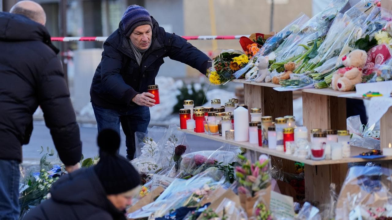 People bring flowers to the Le Constellation bar in Crans-Montana