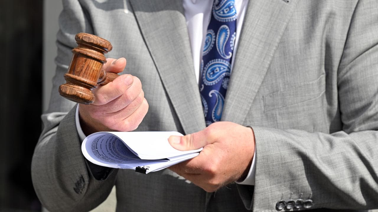 Auctioneer holds a gravel