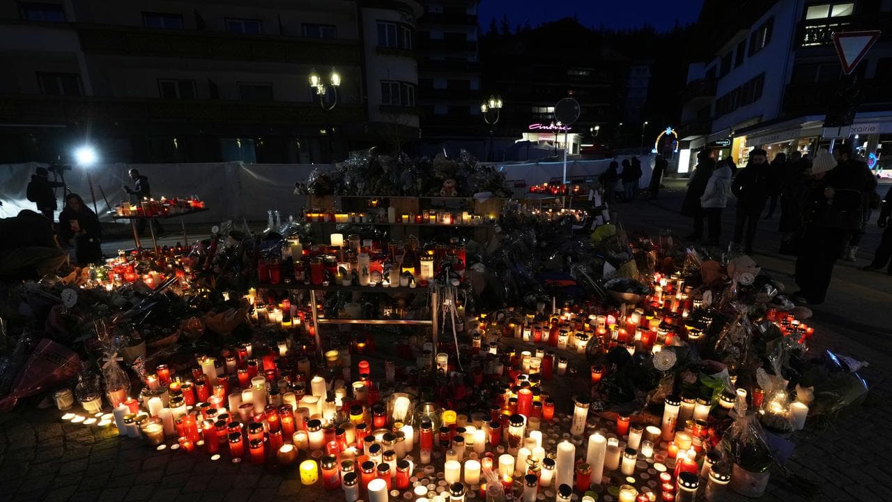 People light candles and place floral tributes in Crans-Montana