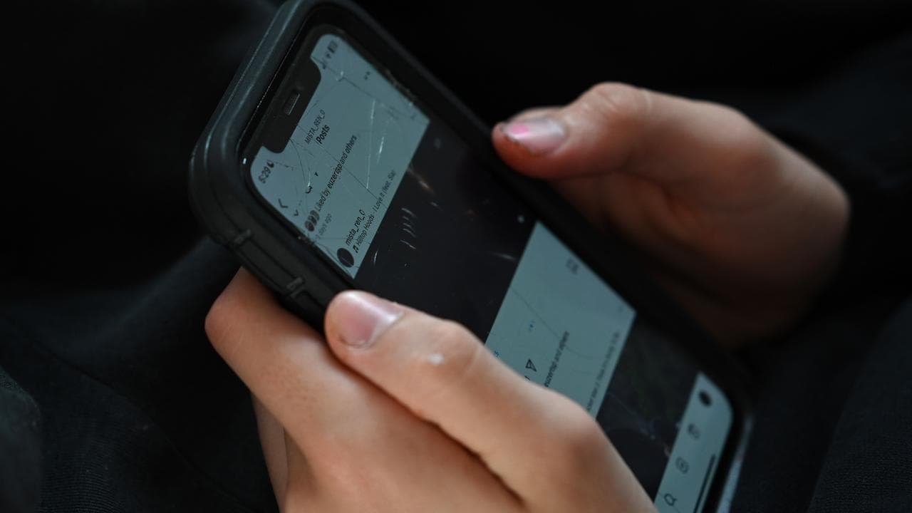 A young person holds a mobile phone