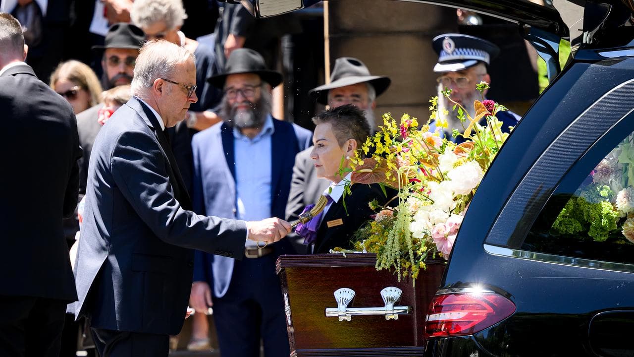 Prime Minister Anthony Albanese places holy water on the coffin