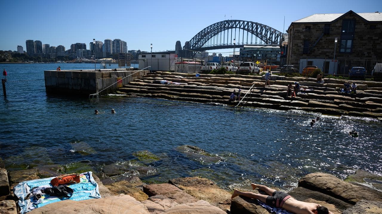 People sunbath at Marrinawi Cove in Sydney