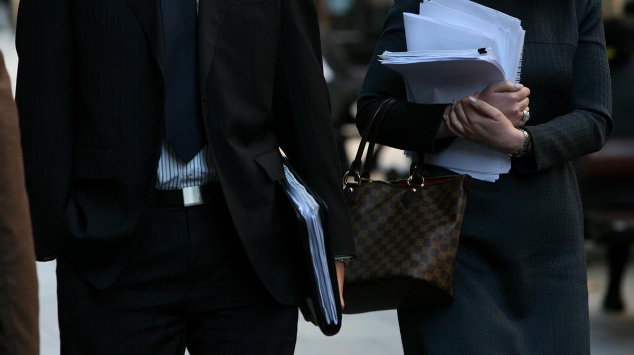 Workers carrying documents walk down Martin Place, Sydney