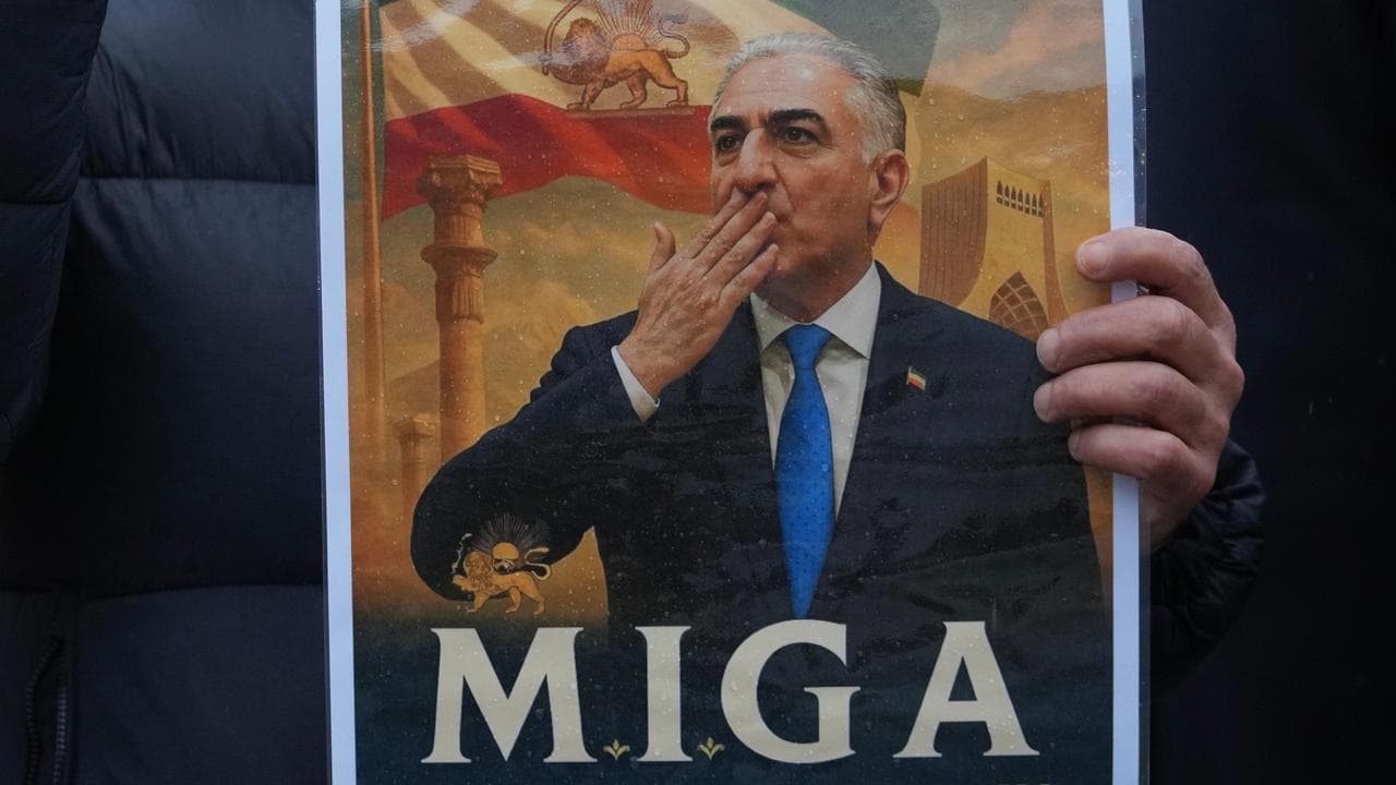 A protester holds a poster of Iran’s exiled Reza Pahlavi in London
