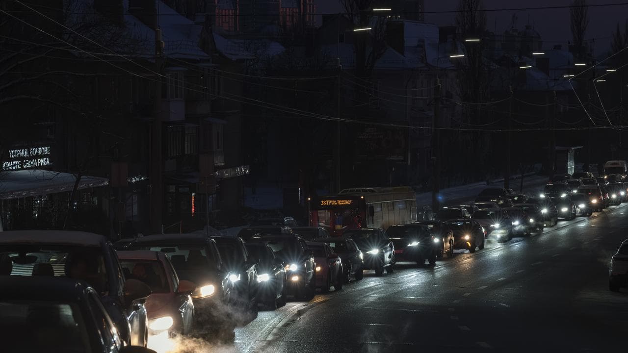 Cars drive along a road during a power outage in downtown Kyiv