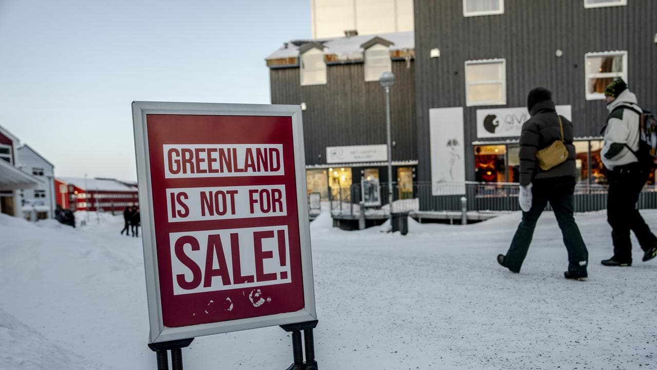 People walk along an icy street in Nuuk, Greenland