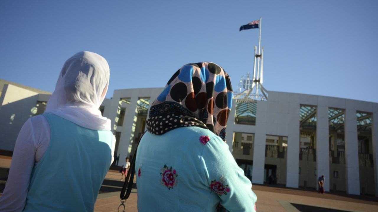 Visitors of Afghan nationality wearing hijabs outside Parliament House