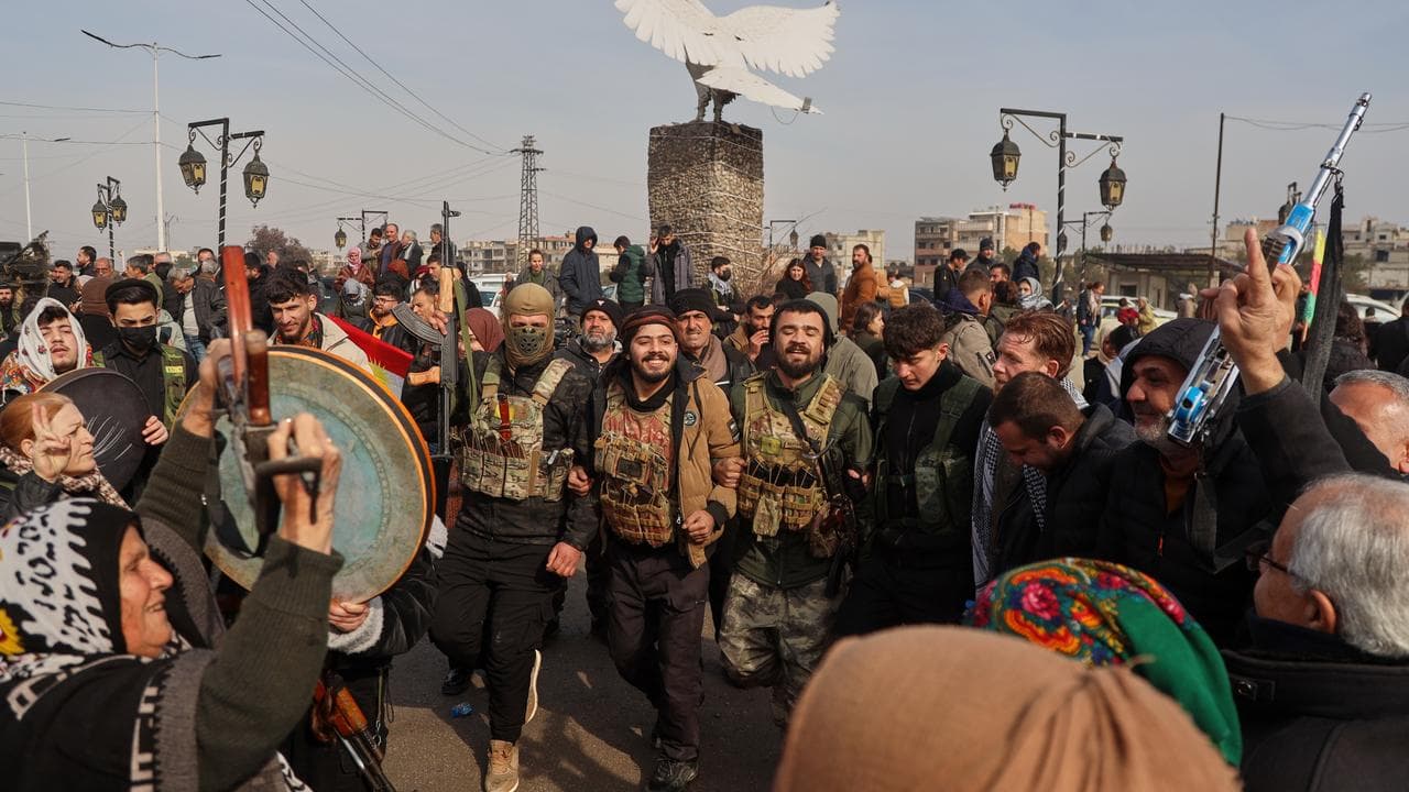 Kurdish fighters with the Syrian Democratic Forces are cheered
