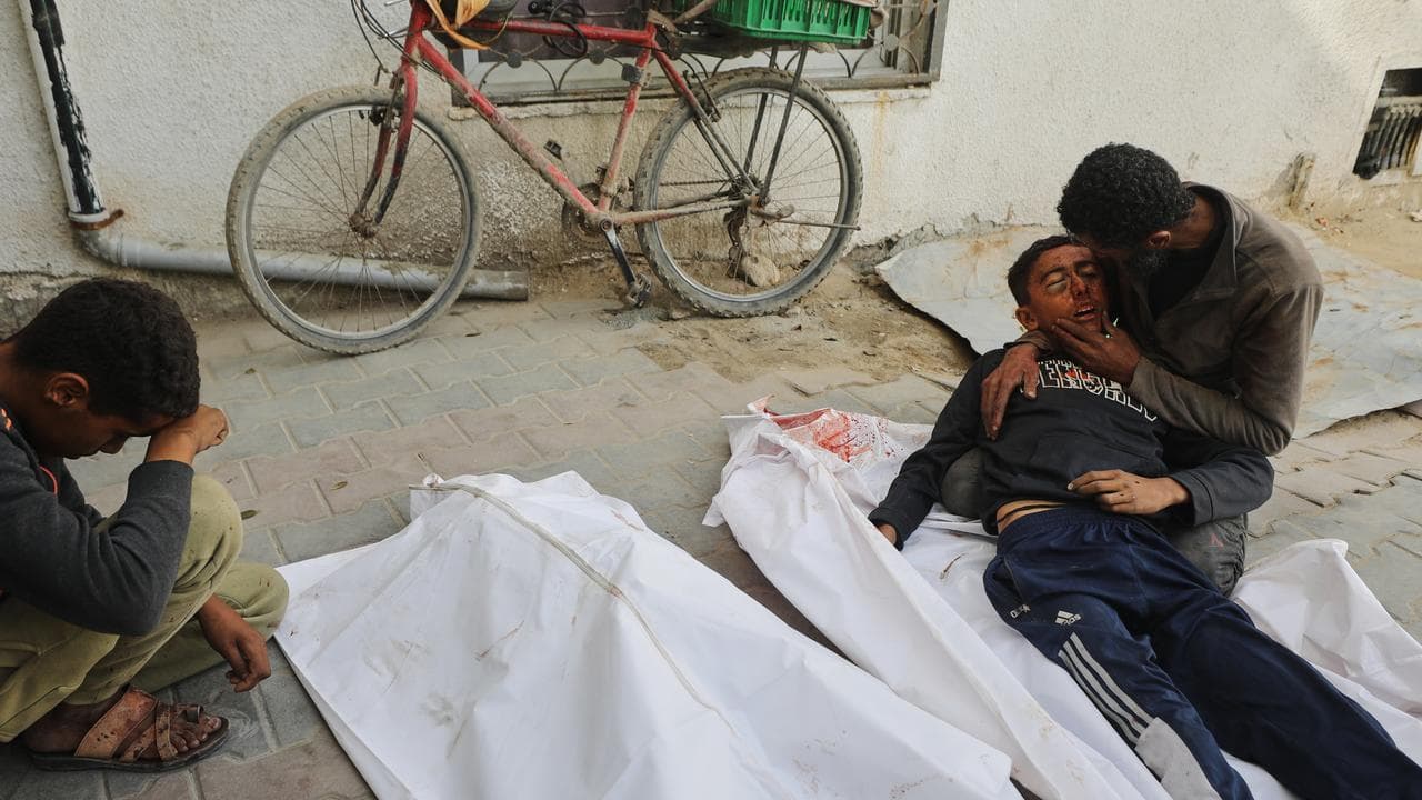 Yusuf Zawara mourns over the body of his son, Mohammad Zawara, 15