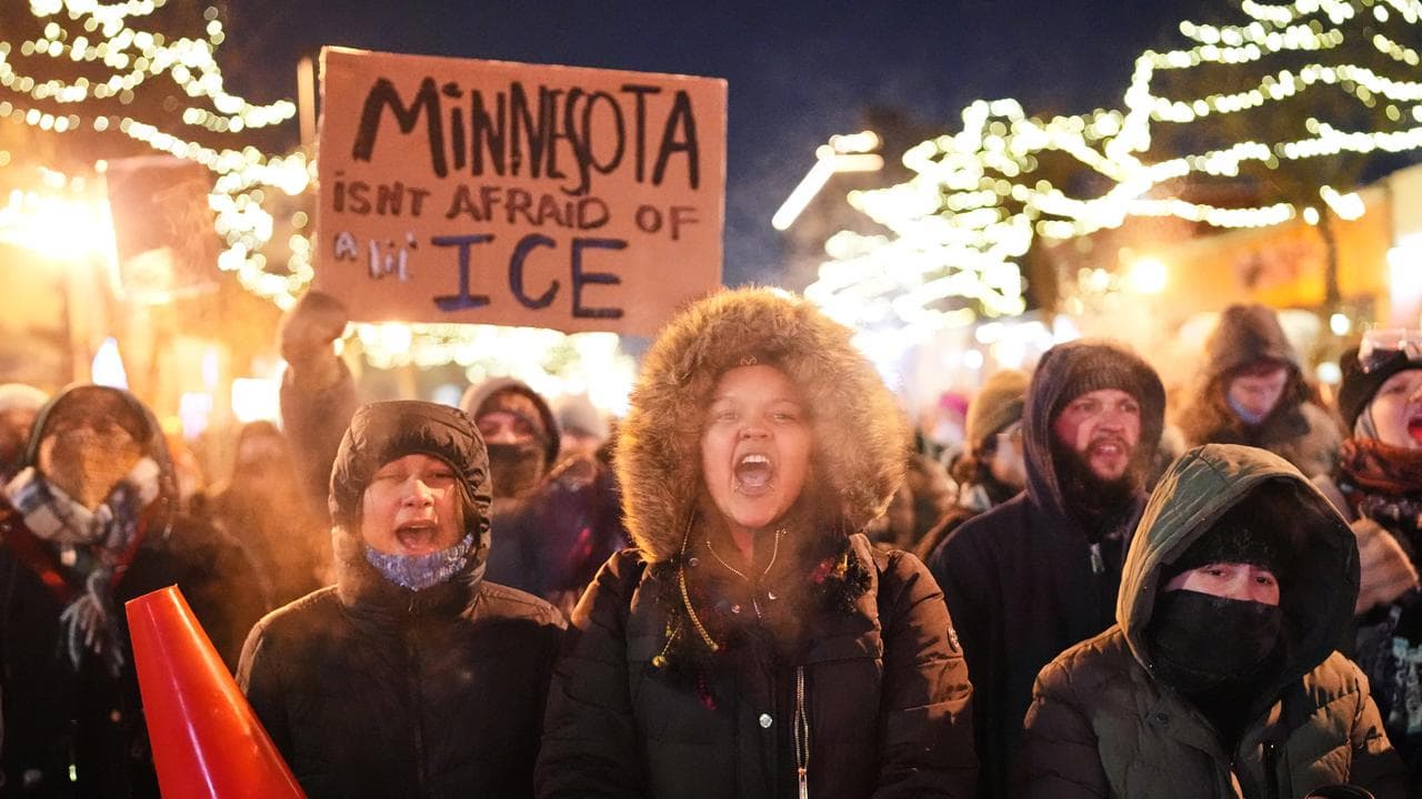 Protesters chant as they stand behind a makeshift barricade