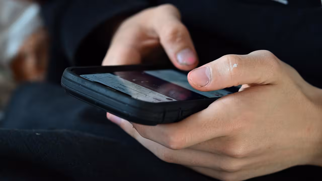 A teenager uses his mobile phone