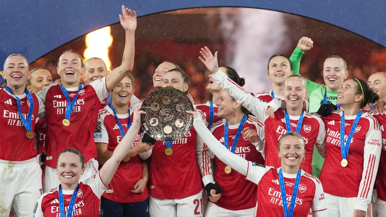 Arsenal players lift the trophy.