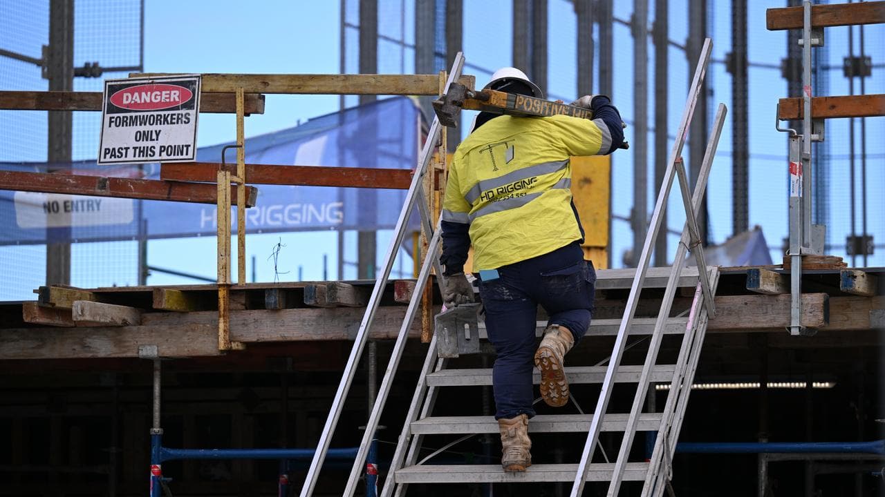A construction worker carrying a beam