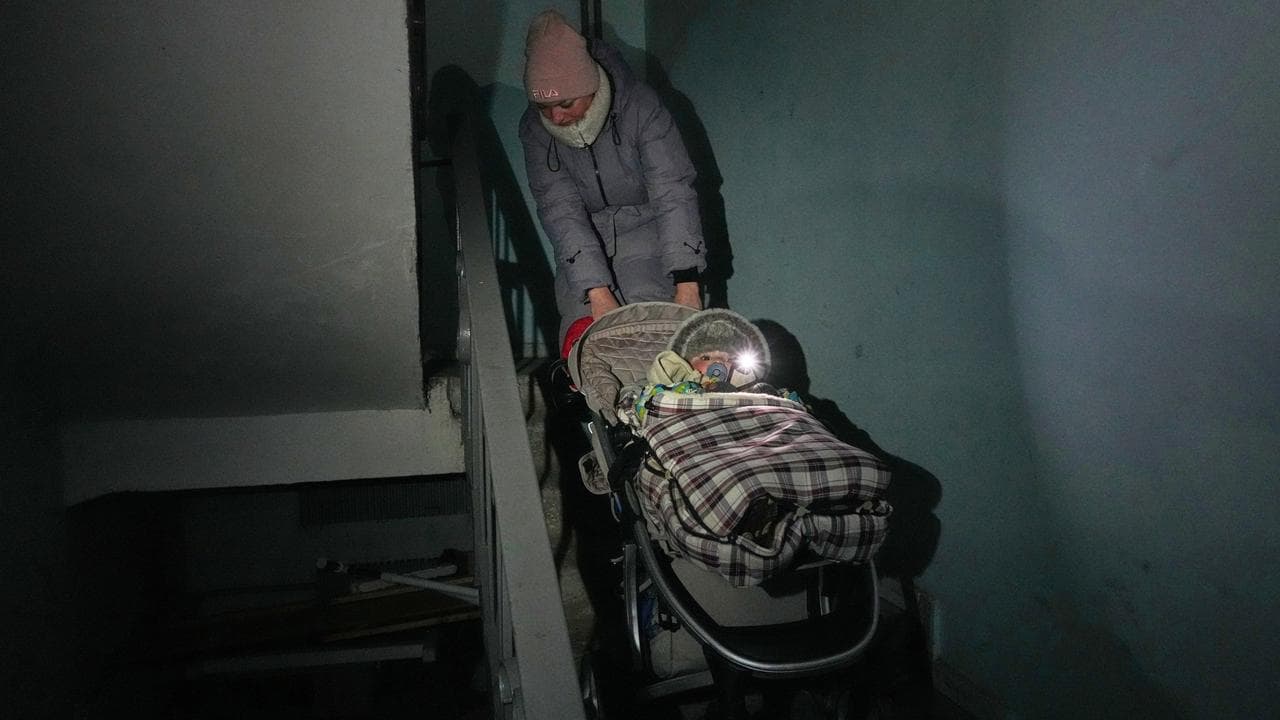 A Kyiv woman pulls a stroller upstar during a blackout (file image)