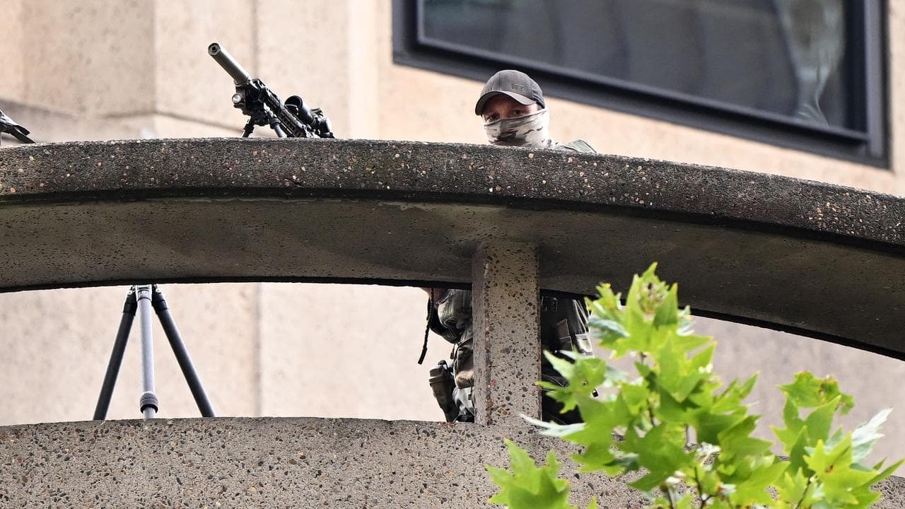 A sniper in position at a hotel