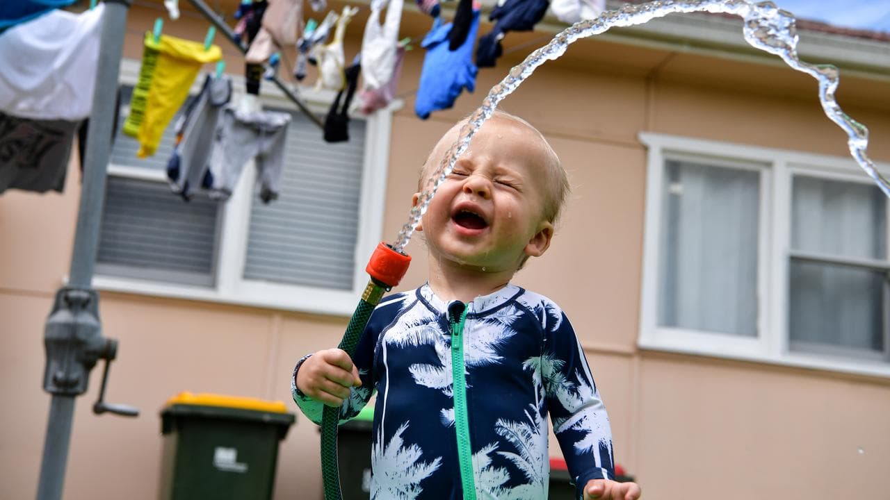 A boy with a garden hose.