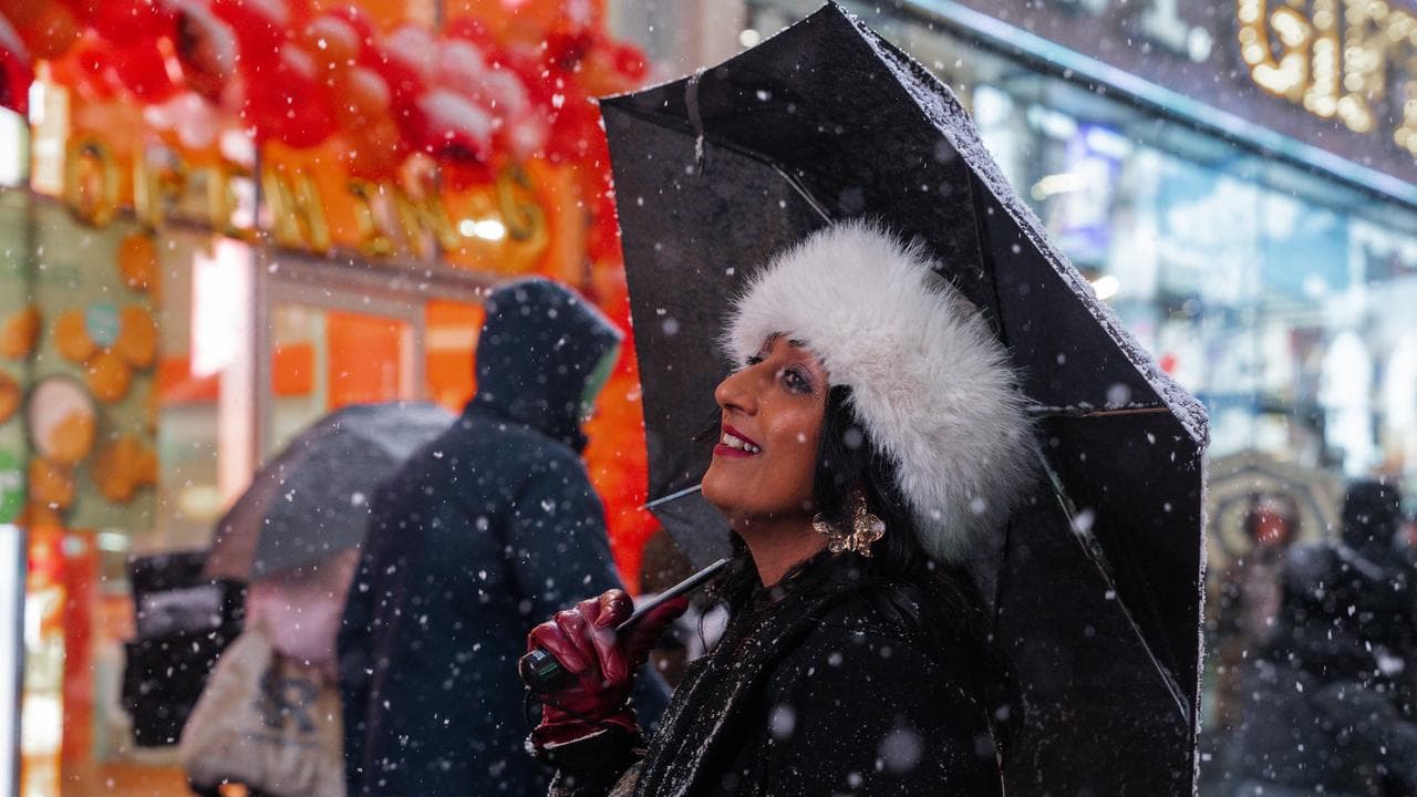A woman carries an umbrella in Times Square