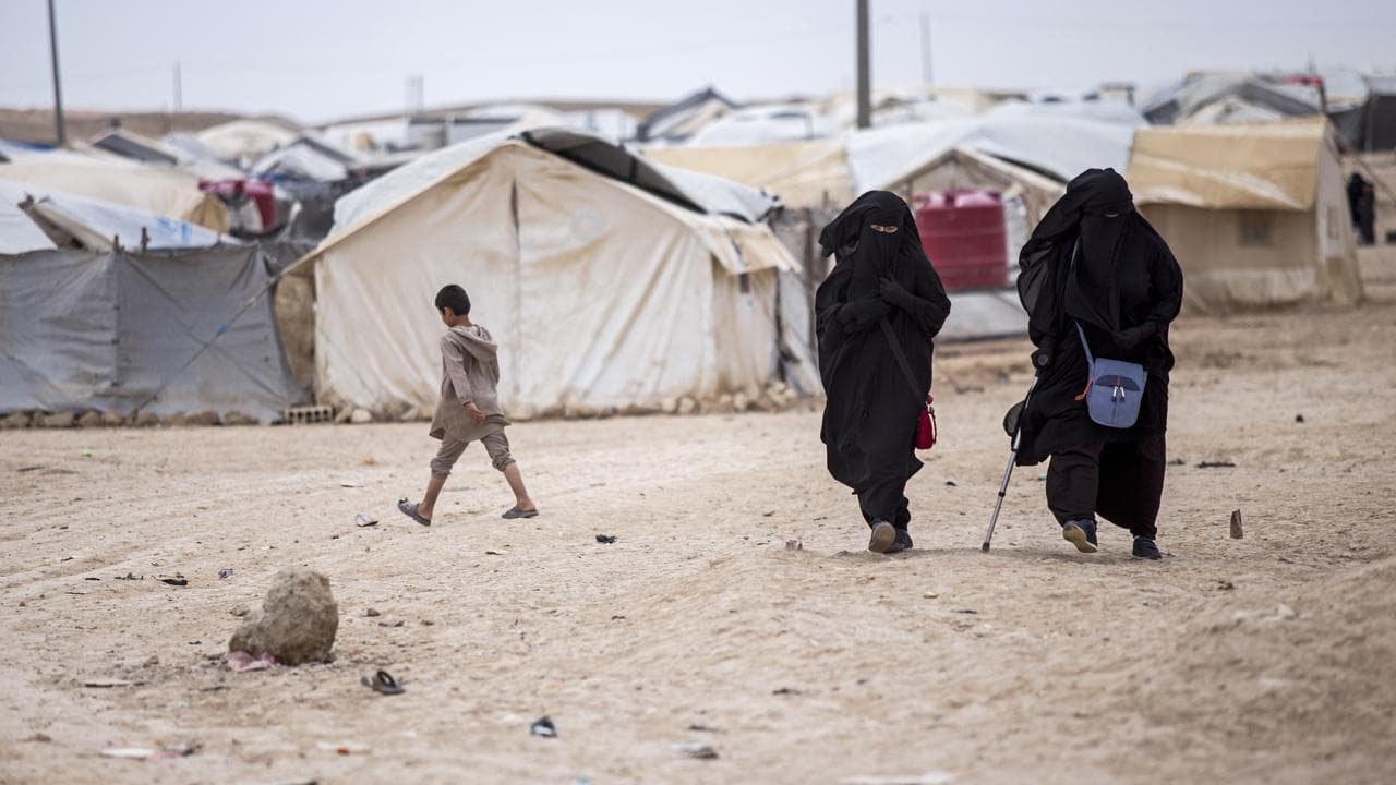 Women walk in the al-Hol camp in Hasakeh province, Syria