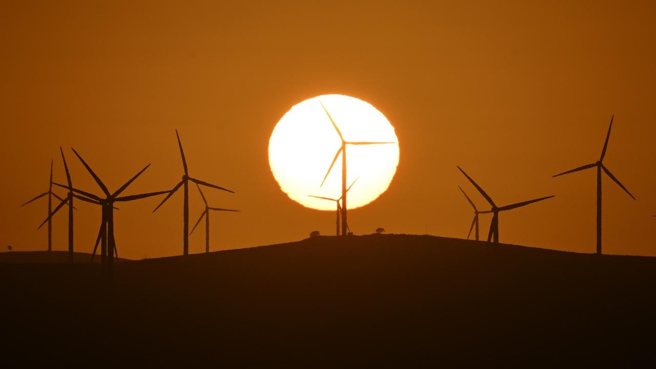 The sun rises over power-generating wind turbines (file image)