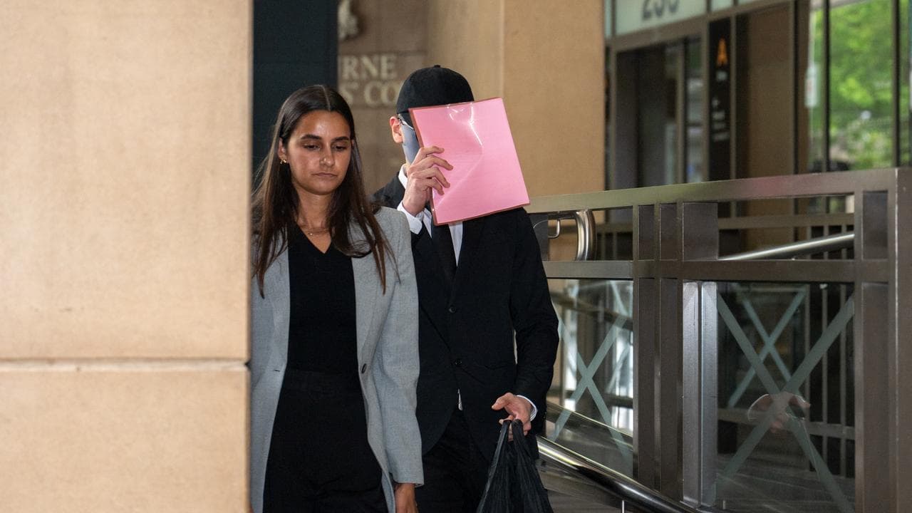 Ryan Cho, hiding his face, exits Melbourne Magistrates Court