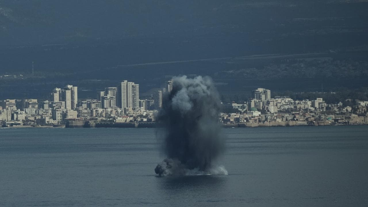 An incoming projectile explodes over the water in Haifa Bay