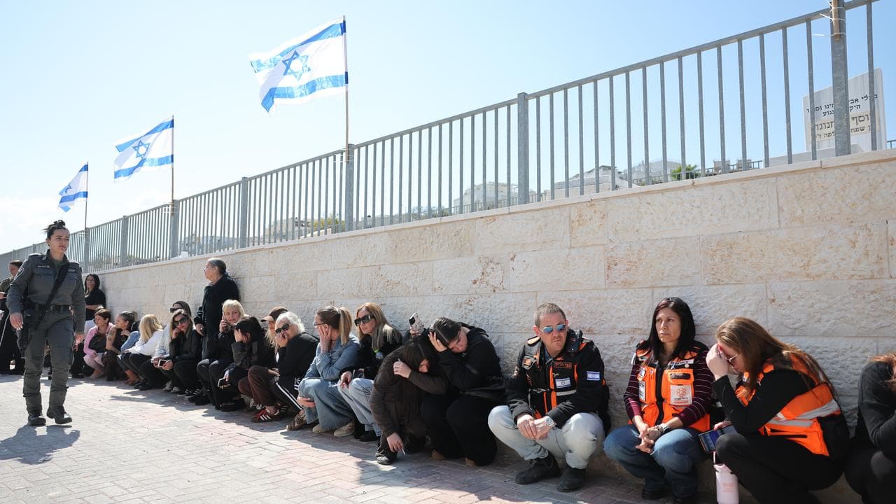 Mourners take cover as sirens sound