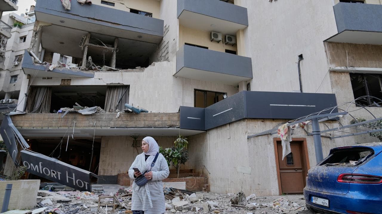 A woman in front of a damaged hotel in Beirut