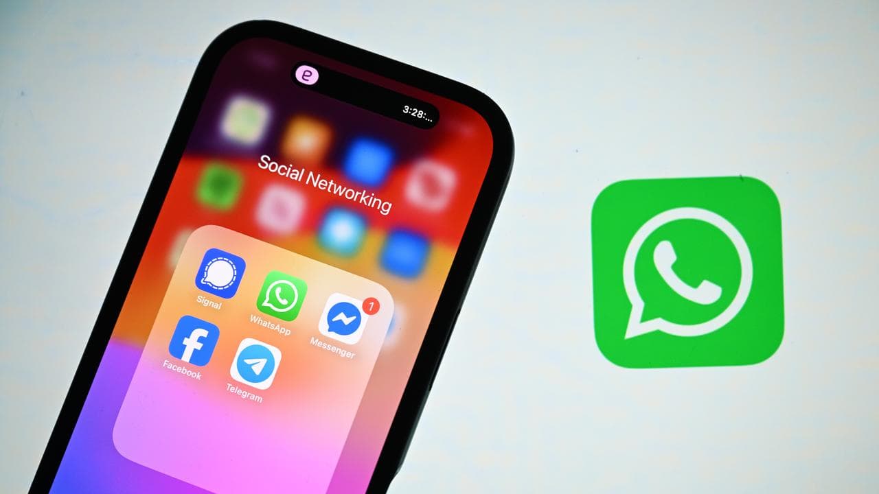 A smart phone in front of a WhatsApp logo