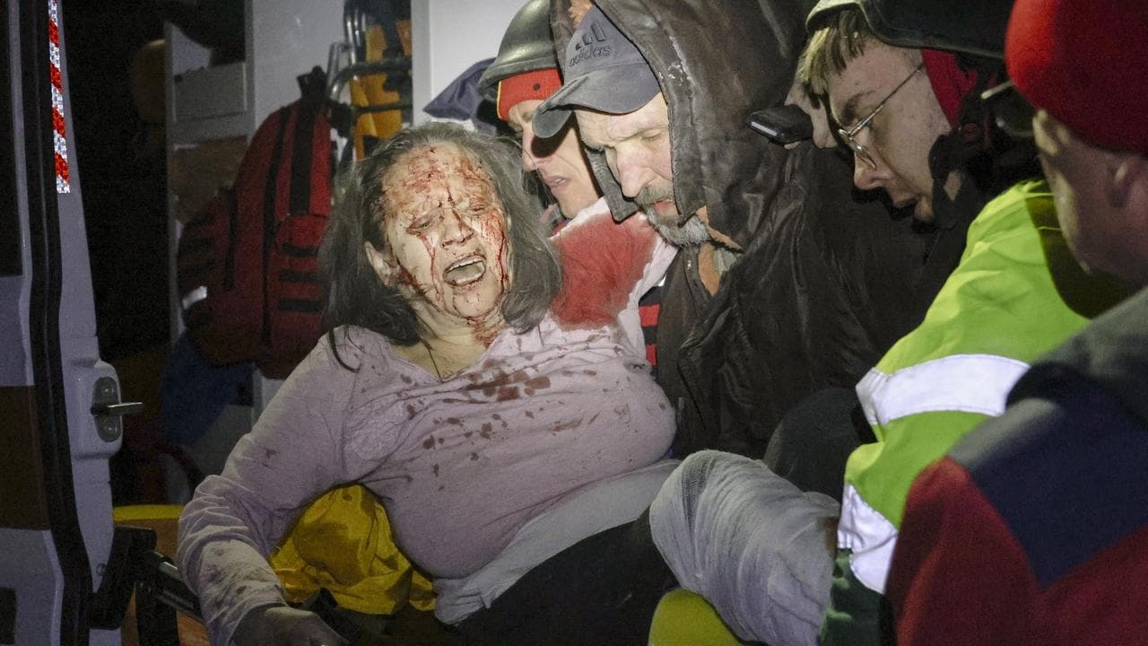 Rescuers help an injured woman after a Russian strike in Kharkiv