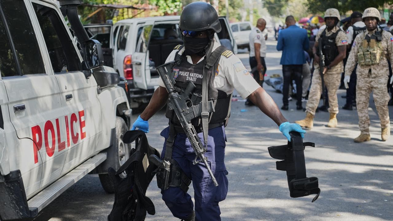 A police officer carries equipment seized from  kidnapper's car